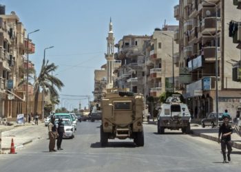 Una fotografía tomada el 26 de julio de 2018, muestra a policías egipcios conduciendo por una carretera que conduce a la capital provincial de El-Arish en el norte del Sinaí. (AFP PHOTO / Khaled DESOUKI)