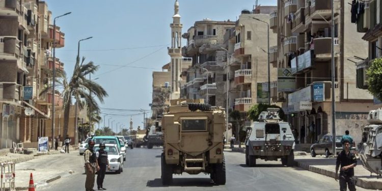 Una fotografía tomada el 26 de julio de 2018, muestra a policías egipcios conduciendo por una carretera que conduce a la capital provincial de El-Arish en el norte del Sinaí. (AFP PHOTO / Khaled DESOUKI)