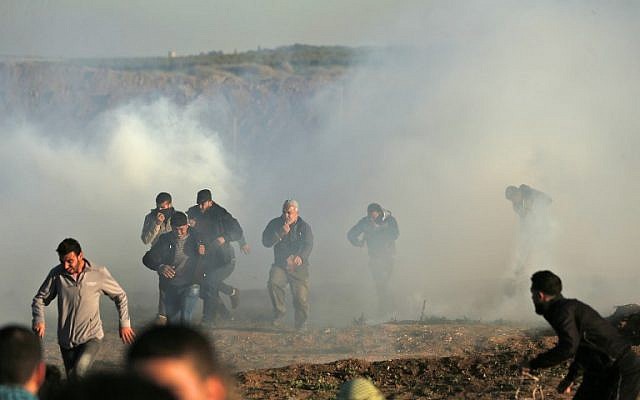 Los palestinos atraviesan humos de gas lacrimógeno durante los enfrentamientos con las fuerzas israelíes durante una manifestación a lo largo de la frontera con Israel al este de la ciudad de Gaza el 11 de enero de 2019. (Foto de MAHMUD HAMS / AFP)