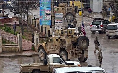 Una captura de imagen tomada de un video obtenido por AFPTV el 16 de enero de 2019, muestra a las tropas estadounidenses reunidas en el lugar de un ataque suicida en la ciudad de Manbij, en el norte de Siria. (AFP)