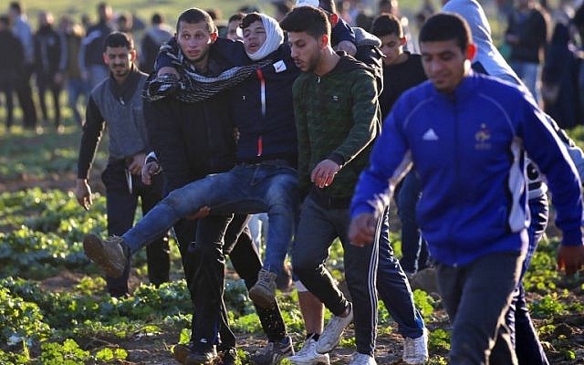 Los palestinos se llevan a un manifestante herido durante los enfrentamientos con las fuerzas israelíes en una manifestación en la frontera con Israel al este de la ciudad de Gaza el 18 de enero de 2019. (Dijo KHATIB / AFP)
