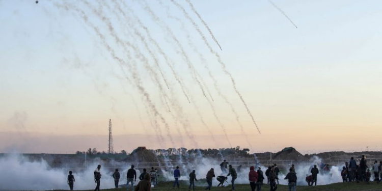 Recipientes de gas lacrimógeno cayendo en medio de manifestantes palestinos durante enfrentamientos con fuerzas israelíes al otro lado de la frontera, al este de la ciudad de Gaza, 18 de enero de 2019. (Dijo KHATIB / AFP)