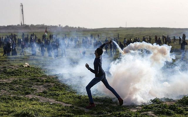 n palestino lanza un bote de gas lacrimógeno hacia las fuerzas israelíes durante los enfrentamientos en la frontera con Israel, al este de la ciudad de Gaza, el 25 de enero de 2019. (Mahmud Hams / AFP)