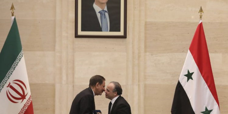 El primer ministro sirio, Imad Khamis, a la derecha, y el vicepresidente iraní, Eshaq Jahangiri, se dan la mano tras la firma de un acuerdo en la capital, Damasco, el 28 de enero de 2019. (LOUAI BESHARA / AFP)