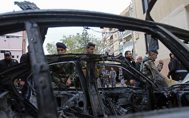 Las fuerzas de seguridad libanesas revisan un vehículo dañado después de la explosión de un coche bomba en la ciudad portuaria de Sidon, en el sur de Líbano, el 14 de enero de 2018. (AFP PHOTO / Mahmoud ZAYYAT)