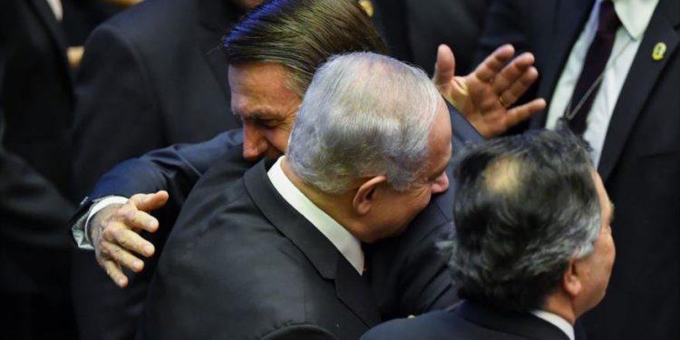 El recién juramentado presidente de Brasil, Jair Bolsonaro (C), saluda al primer ministro Benjamin Netanyahu (L), durante su ceremonia de inauguración, en el Congreso Nacional de Brasilia el 1 de enero de 2019. (Nelson Almeida / AFP)