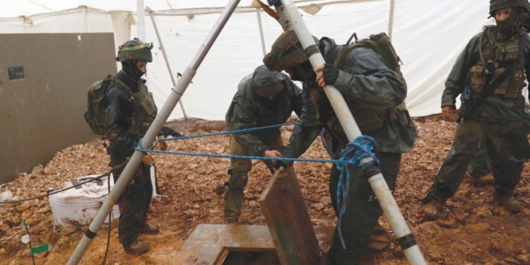 IDF SOLDIERS levanta la tapa de un agujero en un túnel transfronterizo excavado desde el Líbano hacia Israel, cerca de Metulla, el mes pasado. (Crédito de la foto: RONEN ZVULUN / REUTERS)