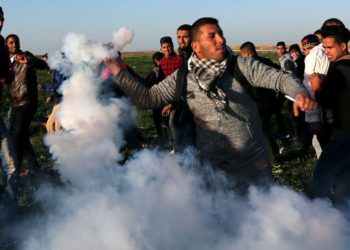 Un manifestante palestino devuelve un bote de gas lacrimógeno disparado por tropas israelíes durante una protesta en la valla fronteriza entre Israel y Gaza, en el sur de la Franja de Gaza, enero 4,2019. (Crédito de la foto: IBRAHEEM ABU MUSTAFA / REUTERS)