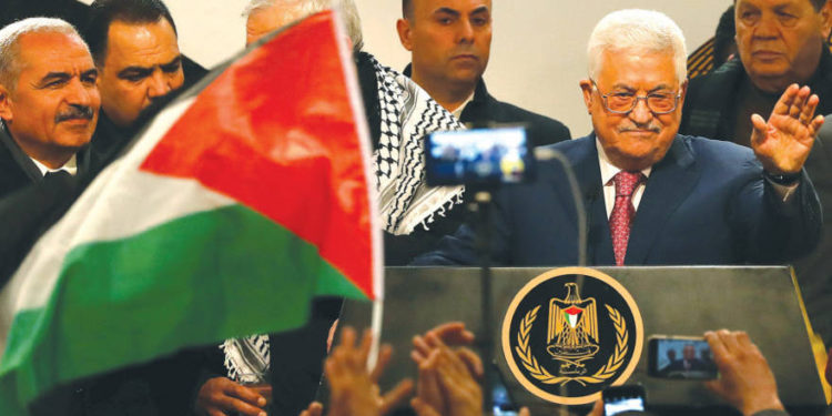 El PRESIDENTE DE LA AUTORIDAD PALESTINA Mahmoud Abbas saluda a la audiencia durante una ceremonia en Ramallah el 31 de diciembre, que marca el 54 aniversario de la fundación de Fatah. (Crédito de la foto: MOHAMAD TOROKMAN / REUTERS)