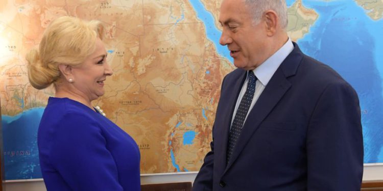 El primer ministro Benjamin Netanyahu da la mano al primer ministro rumano, Viorica Dăncilă. (Crédito de la foto: AMOS BEN-GERSHOM / GPO)