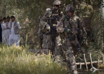 Hombres afganos observan a soldados del ejército alemán patrullando cerca de Char Darah, en las afueras de Kunduz, Afganistán, 20 de septiembre de 2011. (Anja Niedringhaus / AP)