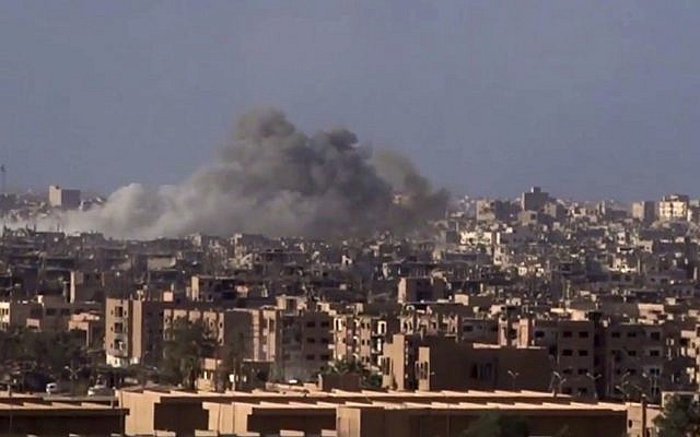 Archivo: Humo y escombros en aumento después del bombardeo del gobierno sirio de la ciudad de Deir el-Zour durante una batalla contra el Estado Islámico en 2017 (SANA a través de AP)