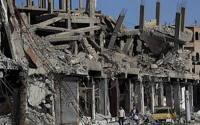 En esta foto del jueves 5 de abril de 2018, escombros de edificios se alinean en una calle que fue dañada durante los enfrentamientos entre combatientes de las Fuerzas Democráticas Sirias respaldados por Estados Unidos y militantes del Estado Islámico, en Raqqa, Siria. (AP / Hussein Malla)