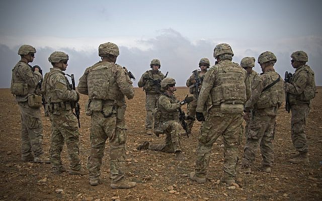 En esta foto del 7 de noviembre de 2018 lanzada por el Ejército de los EE. UU., Los soldados de EE. UU. Se reúnen durante un ensayo conjunto de patrullas conjuntas en Manbij, Siria (foto del Ejército de EE. UU. Por la Ze. Zoe Garbarino a través de AP)