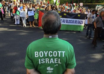 Los manifestantes gritan consignas durante un mitin en París, Francia, el 3 de junio de 2010, mientras se manifiestan contra el ataque de Israel contra un barco de ayuda con destino a Gaza; un hombre en primer plano lleva una camiseta que pide un boicot a Israel. (Jacques Brinon / AP)