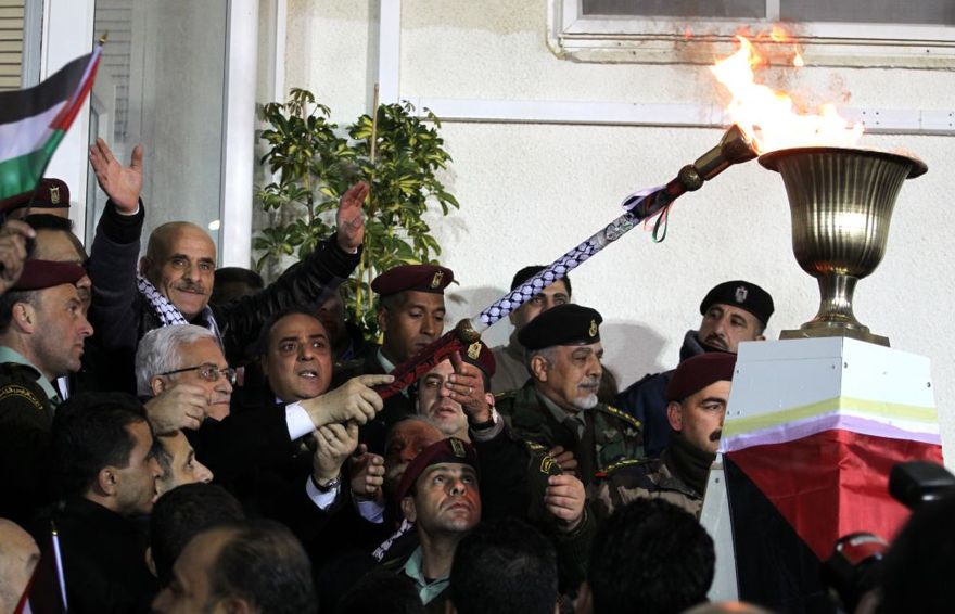 El presidente de la Autoridad Palestina, Mahmoud Abbas, enciende una antorcha conmemorativa en Ramallah el martes temprano. (Crédito de la foto: Hadas Parush / Flash90)