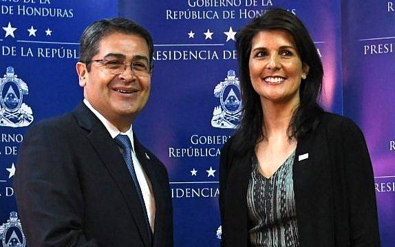 El reelegido presidente de Honduras, Juan Orlando Hernández (L) le da la mano a la embajadora de Estados Unidos ante las Naciones Unidas, Nikki Haley, antes de hablar con la prensa en Tegucigalpa, el 27 de febrero de 2018.  (AFP PHOTO / Orlando SIERRA)