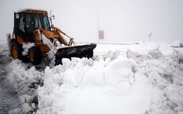 Un tractor quita nieve en la carretera en la intersección de Al Hader en Cisjordania, sábado 14 de diciembre de 2013. (Nati Shohat / Flash 90)