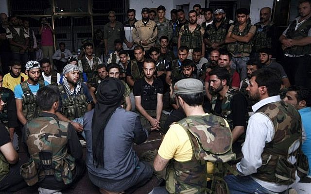 En esta foto del 29 de julio de 2012, los soldados del Ejército Sirio Libre se reúnen en la ciudad fronteriza de Azaz, a unos 32 kilómetros (32 millas) al norte de Aleppo, Siria. Hombres armados vinculados a Al Qaeda en el norte de Siria capturaron la ciudad cerca de la frontera con Turquía el jueves 19 de septiembre de 2013, luego de fuertes enfrentamientos con los rebeldes de la zona apoyados por Occidente, lo que llevó a Turquía a cerrar un cruce cercano, activistas y turcos. dijeron los funcionarios. (Foto AP / Turkpix, Archivo)