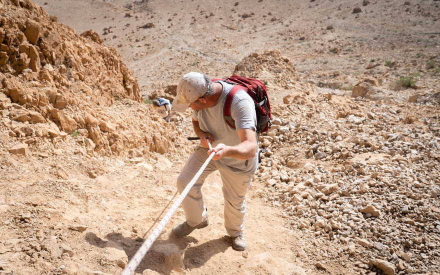 El investigador Oren Gutfeld desciende de la cueva 52, en el sitio arqueológico de Qumran, el 22 de enero de 2019. (Luke Tress / Times of Israel)