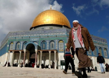 Los palestinos caminan más allá de la Cúpula de la Roca en el complejo de la Mezquita de Al-Aqsa en la Ciudad Vieja de Jerusalén, el 13 de enero de 2017. (Crédito de la foto: AFP PHOTO)