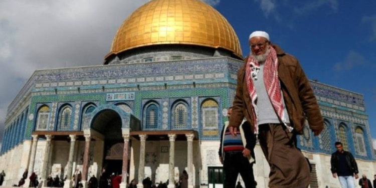 Los palestinos caminan más allá de la Cúpula de la Roca en el complejo de la Mezquita de Al-Aqsa en la Ciudad Vieja de Jerusalén, el 13 de enero de 2017. (Crédito de la foto: AFP PHOTO)