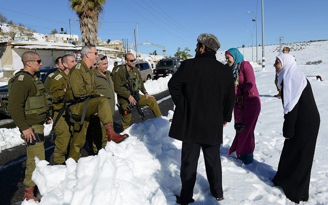 El entonces jefe de personal de las FDI, Benny Gantz, habla con una familia de palestinos a lo largo de la ruta 60 de la Ribera Occidental, el 15 de diciembre de 2013. (Judah Ari Gross / Fuerzas de Defensa de Israel)