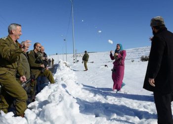 El entonces jefe de personal de las FDI Benny Gantz tiene una pelea de bolas de nieve con una familia de palestinos a lo largo de la ruta 60 de la Ribera Occidental, el 15 de diciembre de 2013. (Judah Ari Gross / Fuerzas de Defensa de Israel)