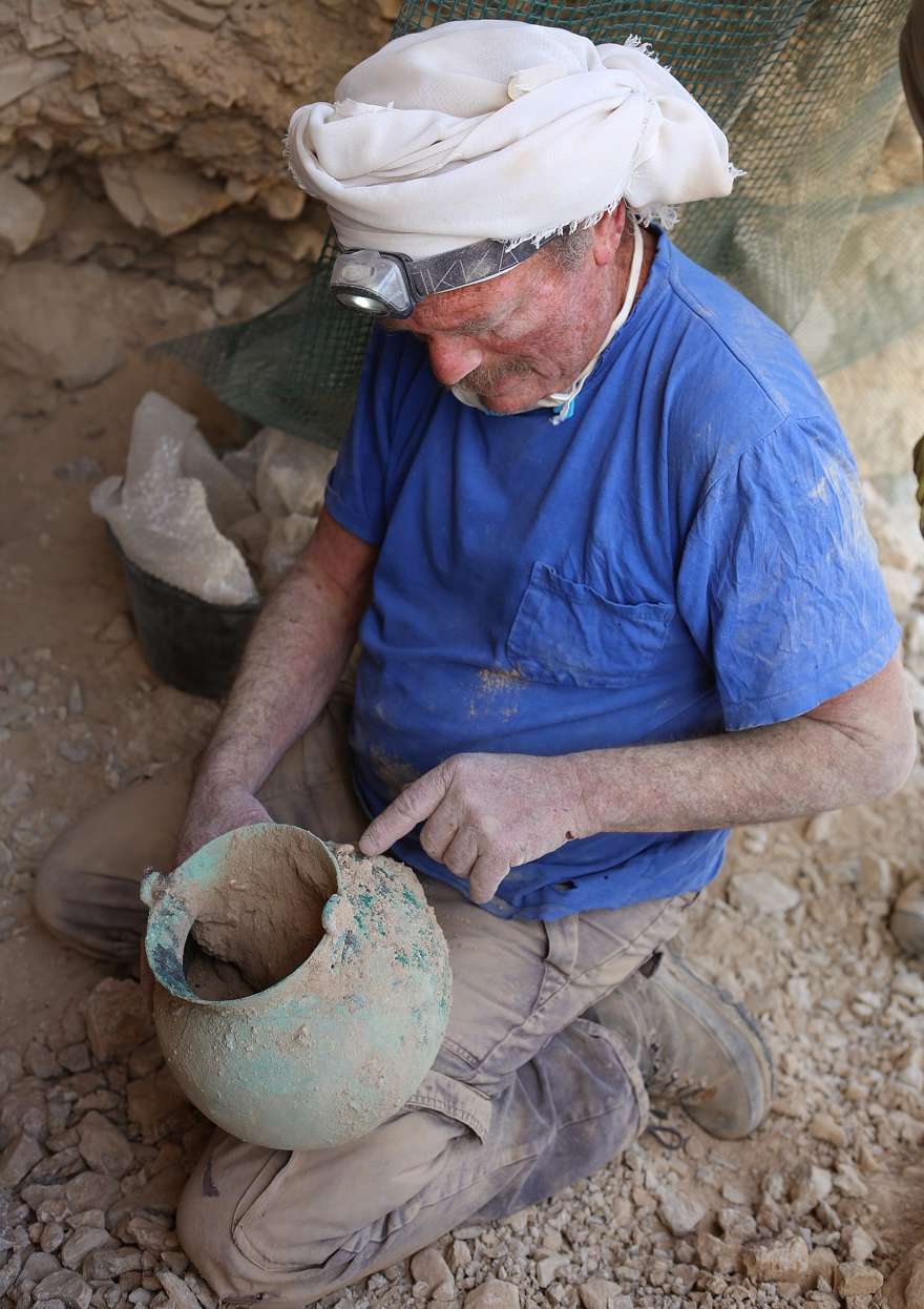 Yakov Kalman tiene la olla de bronce de 2.000 años de antigüedad descubierta en la Cueva 53B en Qumran, sobre el Mar Muerto. (Casey Olson)