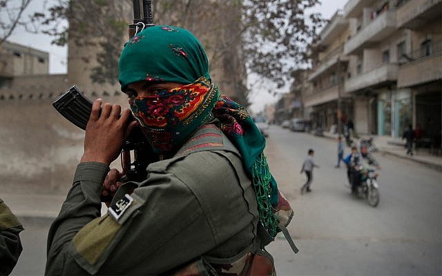 Un miembro de las fuerzas de seguridad internas kurdas sostiene su waepon durante una patrulla en Manbij, norte de Siria, 28 de marzo de 2018, (Foto AP / Hussein Malla)