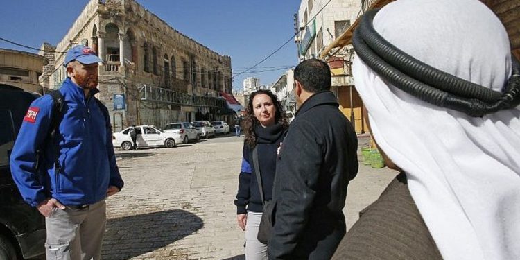 Los miembros de la Presencia Internacional Temporal en Hebrón (TIPH) hablan con los palestinos locales mientras caminan en la ciudad de Cisjordania el 29 de enero de 2019. (Hazem Bader / AFP)