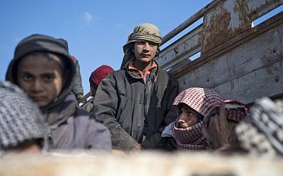 El 11 de febrero de 2019 (Fadel Senna / AFP) pararon en la parte trasera de un camión los hombres que se cree que son civiles que huyen de la huelga del Estado Islámico de Baghouz en Deir Ezzor.