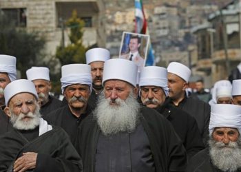 Los residentes drusos de los Altos del Golán llevan un retrato del presidente sirio Bashar al-Assad durante un mitin en la aldea de Majdal Shams el 14 de febrero de 2019 (JALAA MAREY / AFP)