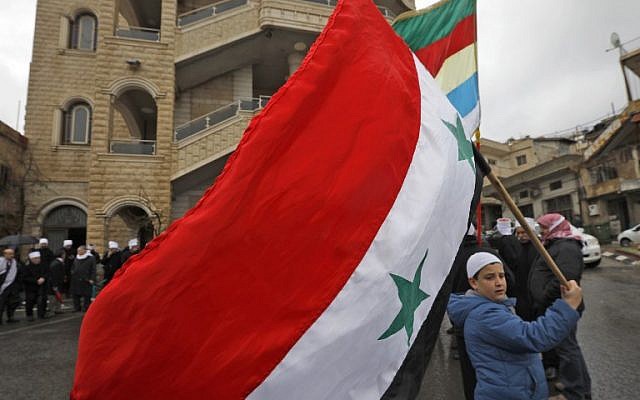 El joven druso residente en los Altos del Golán ondea la bandera nacional siria durante un mitin en la aldea de Majdal Shams en los Altos del Golán el 14 de febrero de 2019 (JALAA MAREY / AFP)