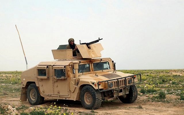 Un combatiente de las Fuerzas Democráticas Sirias respaldado por Estados Unidos se sienta sobre un vehículo militar durante una operación para expulsar a los jihadistas del grupo Estado Islámico (IS) de la zona de Baghouz en Deir Ezzor el 14 de febrero de 2019. (Delil Souleiman / AFP)