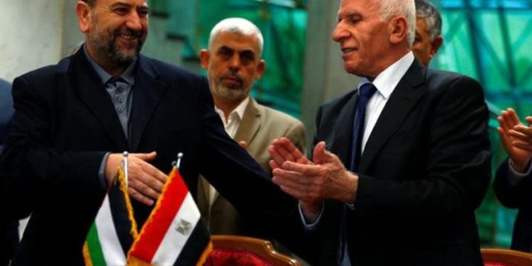 El jefe de la delegación de Hamas, Saleh Arouri, y el líder de Fatah, Azzam Ahmad, firman un acuerdo de reconciliación en El Cairo, Egipto, 12 de octubre de 2017 .. (crédito de foto: REUTERS / AMR ABDALLAH DALSH)