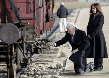 El vicepresidente de los EE. UU., Mike Pence, se arrodilla junto a su esposa Karen en un histórico vagón de carga durante su visita al antiguo campo de exterminio nazi de Auschwitz-Birkenau en Oswiecim, Polonia, el viernes 15 de febrero de 2019. El vagón de carga se utilizó para transportar Judios al campamento. (Foto AP / Michael Sohn)