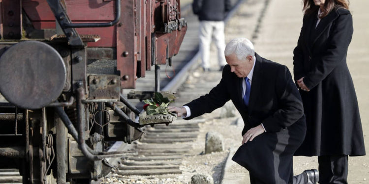 El vicepresidente de los EE. UU., Mike Pence, se arrodilla junto a su esposa Karen en un histórico vagón de carga durante su visita al antiguo campo de exterminio nazi de Auschwitz-Birkenau en Oswiecim, Polonia, el viernes 15 de febrero de 2019. El vagón de carga se utilizó para transportar Judios al campamento. (Foto AP / Michael Sohn)