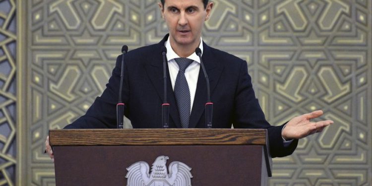 En esta foto publicada por la agencia oficial de noticias siria SANA, el presidente sirio Bashar Assad habló durante una reunión con los jefes de los consejos locales de todas las provincias sirias, en Damasco, Siria, el domingo 17 de febrero de 2018. (SANA a través de AP)