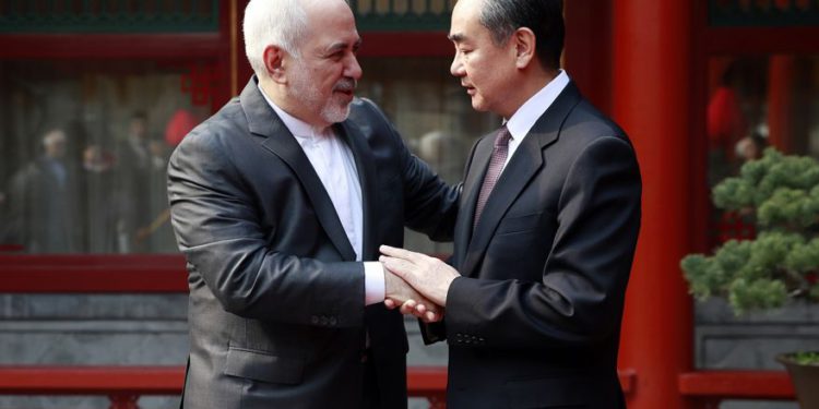 El ministro de Relaciones Exteriores iraní, Mohammad Javad Zarif, a la izquierda, y su homólogo chino, Wang Yi, se dan la mano durante su reunión en la Casa de Huéspedes de Diaoyutai en Pekín, 19 de febrero de 2019. (Cómo Hwee Young / Foto de piscina a través de AP)