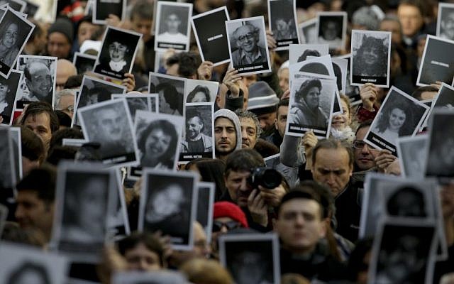 La gente muestra fotos de los que murieron en el atentado con bomba del centro judío de AMIA que mató a 85 personas cuando conmemoraban el 22 aniversario del ataque en Buenos Aires, Argentina, 18 de julio de 2016. (Foto AP / Natacha Pisarenko)