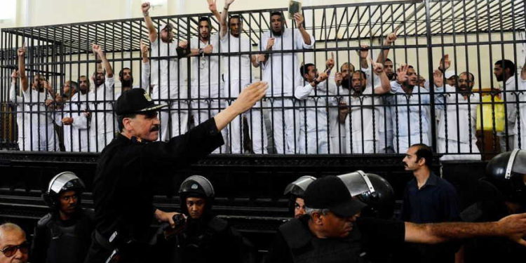 Illustrative: Supporters of the Muslim Brotherhood and other Islamists gesture from the defendants cage as they receive sentences in a mass trial in Alexandria, Egypt, May 19, 2014. (AP Photo/Heba Khamis)