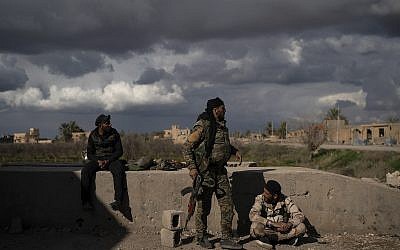 Los combatientes apoyados por las Fuerzas Democráticas Sirias (SDF) respaldados por los EE. UU se encuentran en un área recientemente tomada por SDF de los militantes del Estado Islámico como continuación en la aldea de Baghouz, Siria, el 17 de febrero de 2019. (Foto AP / Felipe Dana)