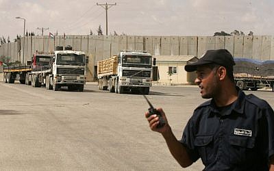 Un policía palestino leal a Hamás monta guardia cuando los camiones que transportan materiales de construcción ingresan a la Franja de Gaza a través del cruce de Kerem Shalom el 22 de septiembre de 2013. (Abed Rahim Khatib / Flash90 / File)