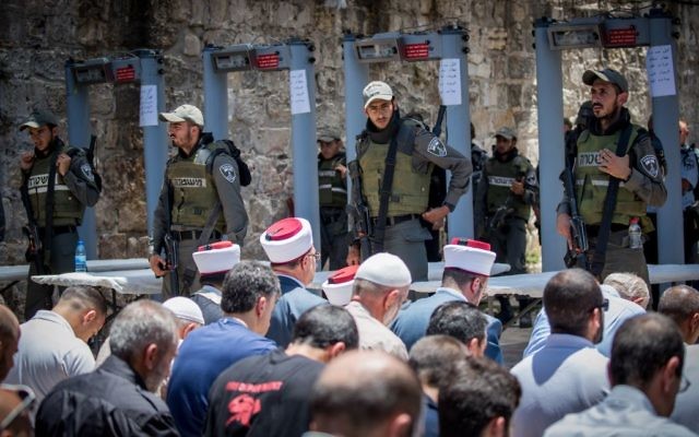 Los funcionarios de Waqf dirigen las oraciones musulmanas fuera del Monte del Templo en la Ciudad Vieja de Jerusalén el 16 de julio de 2017 después de negarse a pasar por las puertas de detectores de metales instaladas por la policía israelí. (Yonatan Sindel / Flash90)