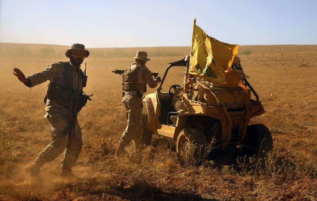 Combatientes de Hezbolá están parados junto a su vehículo militar en el valle de Al-Kheil en la frontera entre el Líbano y Siria, el 29 de julio de 2017. (Foto AP / Bilal Hussein)