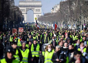 La gente camina por la avenida de los Campos Elíseos el 16 de febrero de 2019 durante la 14ª semana consecutiva de protestas del "chaleco amarillo". (Eric Feferberg / AFP)