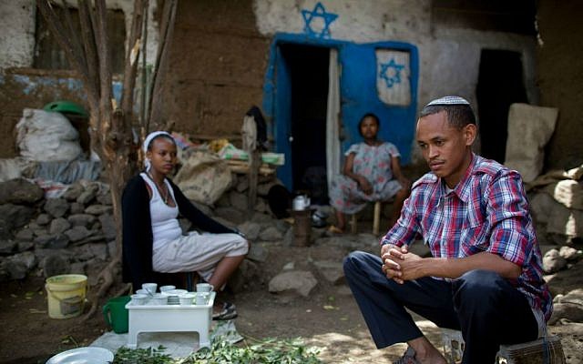 Atenkut Setataw (derecha), con su esposa Alesa Netere (izquierda) y un vecino fuera de su casa en Gondar el 24 de abril de 2016. Setataw pintó la casa. (Miriam Alster / Flash90)