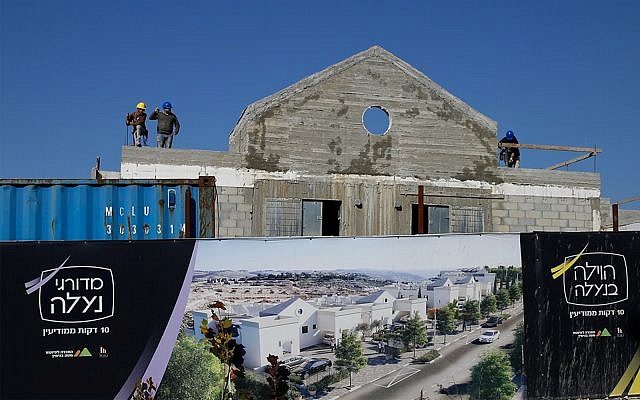 Los hombres trabajan en un nuevo proyecto de vivienda en el asentamiento de Naale en Cisjordania, 1 de enero de 2019. (AP Photo / Ariel Schalit)