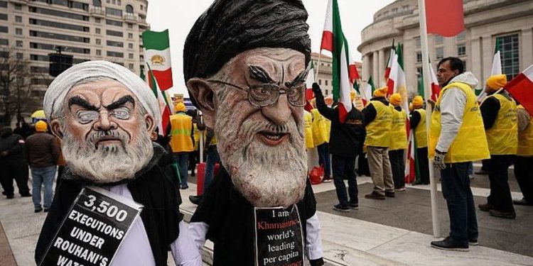 Las efigies del presidente iraní Hassan Rouhani (L) y del líder supremo de Irán, Ayatollah Ali Khamenei (R), marchan con la Organización de Comunidades Iraní-Americanas durante un mitin en apoyo de "los levantamientos nacionales en Irán por el cambio de régimen" el 8 de marzo de 2019. Washington, DC (Mandel NGAN / AFP)